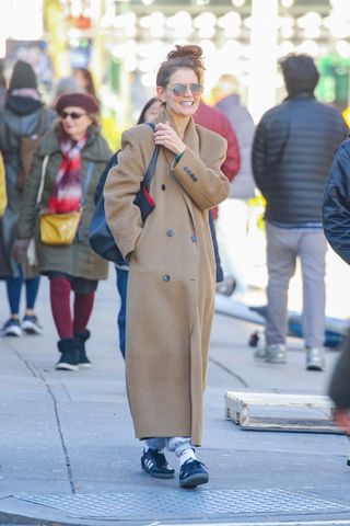 Katie Holmes wearing a camel coat and sweatpants.