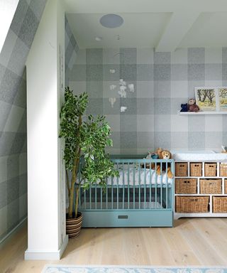 Nursery ideas featuring a textured check wallpaper, wicker basket storage and a pale blue painted crib.