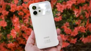 The back of a white Honor 600 with coral flowers in the background