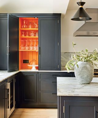 Grey kitchen with orange painted cabinets