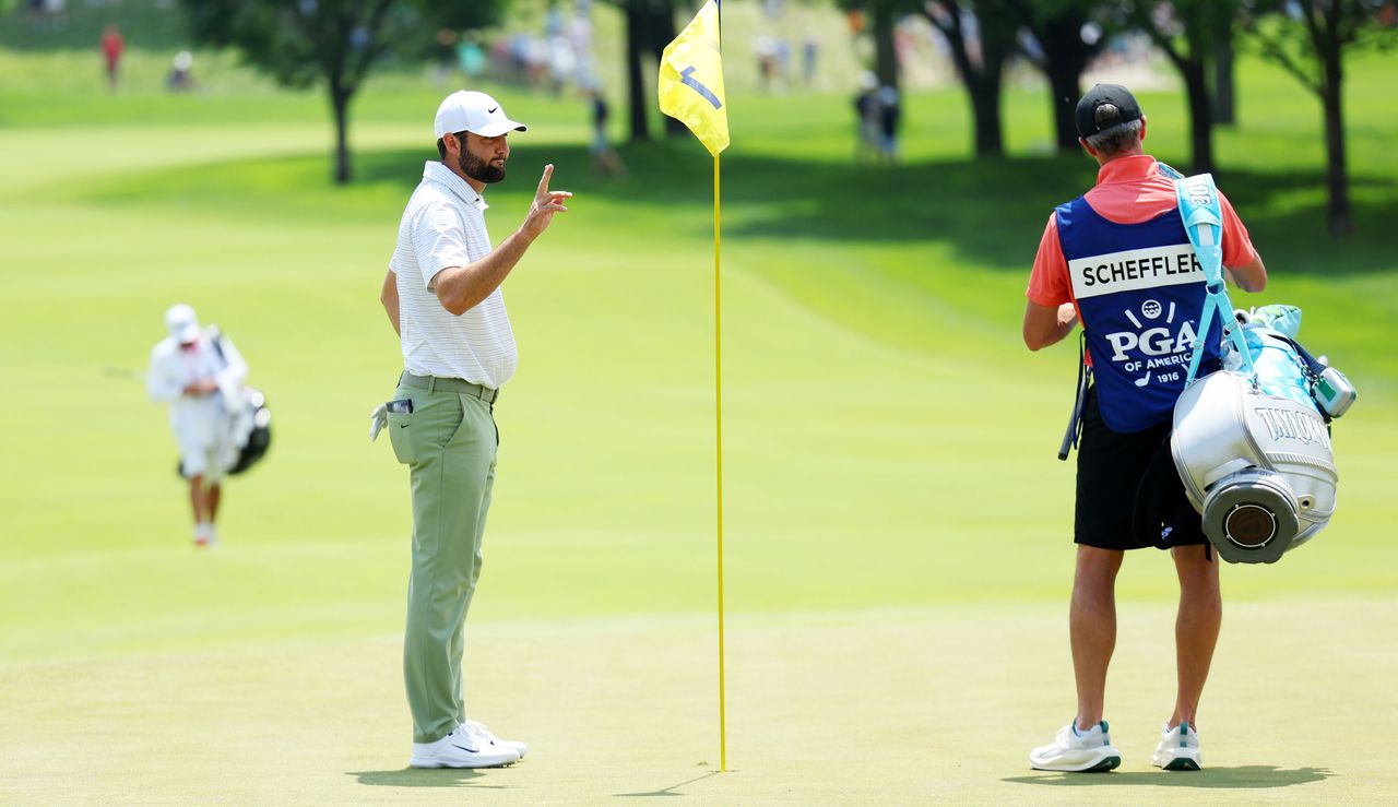 Scottie Scheffler waves to the crowd after holing out at the first hole of the 2024 PGA Championship