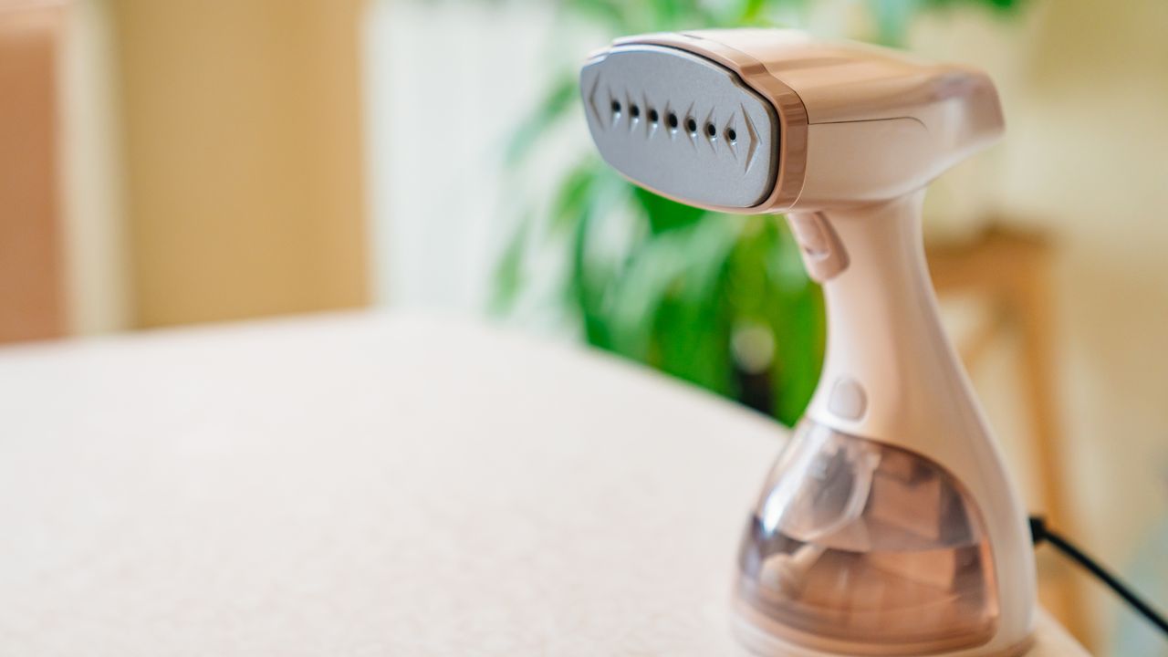 Handheld clothes steamer on tabletop