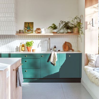 White painted and tiled kitchen with teal cabinets and a sink above them