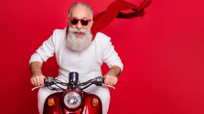 An older man happily rides a scooter.