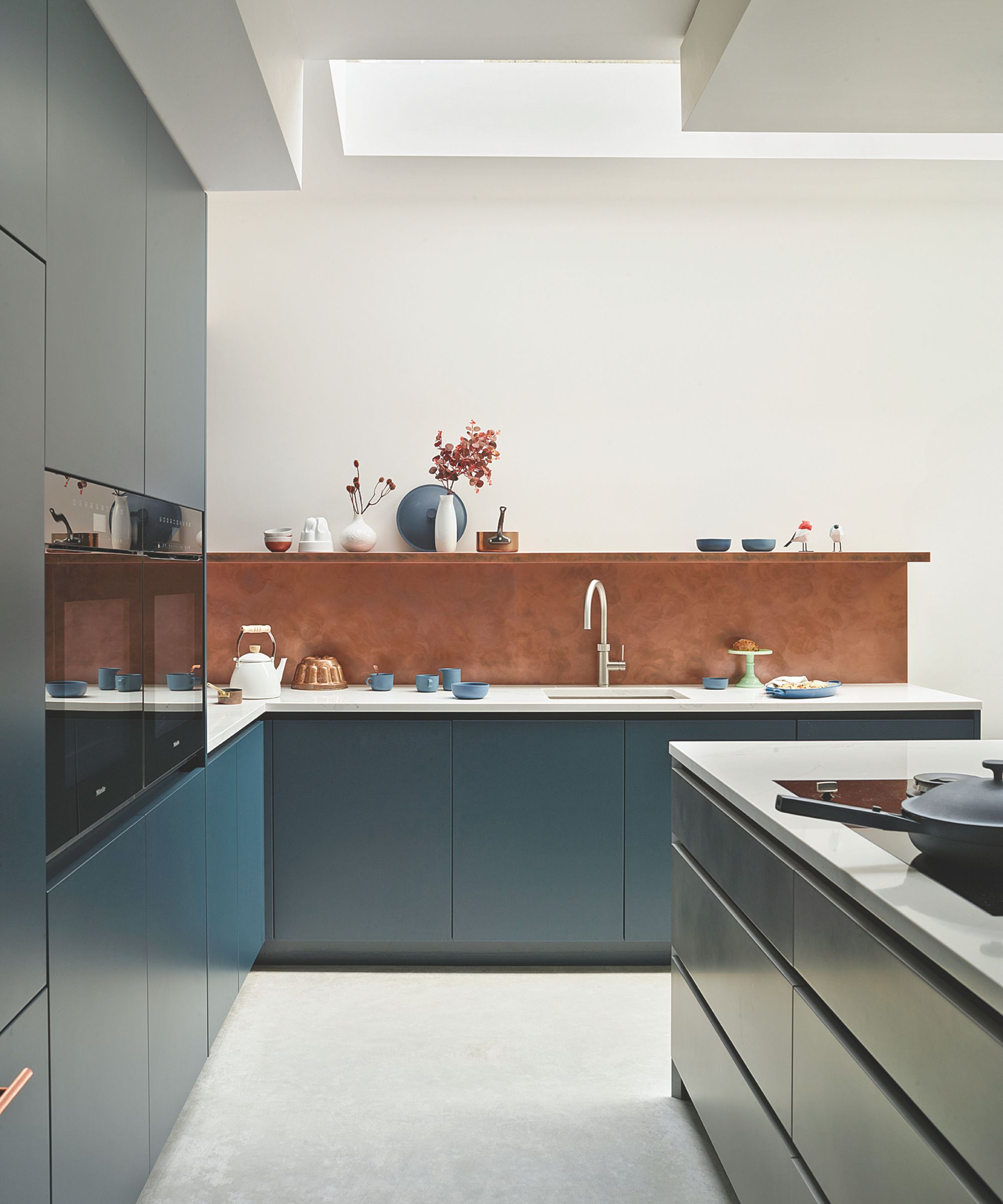 blue cabinetry in kitchen with white walls