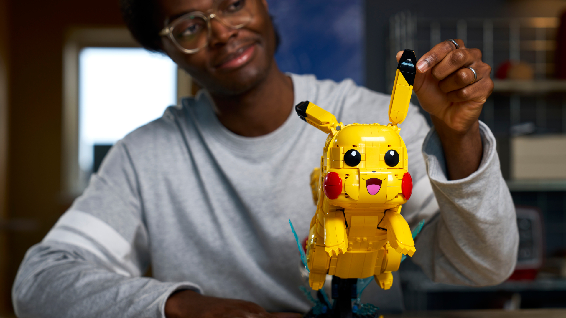 A man moves the ear of the Lego Pikachu and Poke Ball set