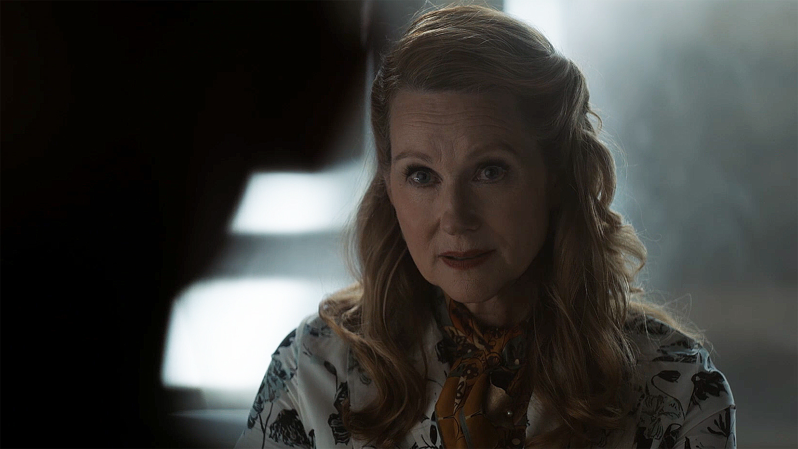 Laura Linney's Lianna sitting opposite an off-camera John Stewart in Lanterns episode 1