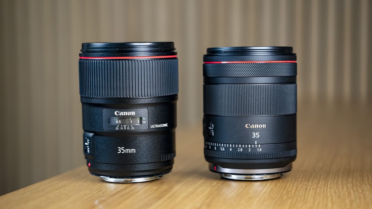 The Canon RF 35mm F1.4 lens on a wooden table alongside the Canon EF 35mm F1.4