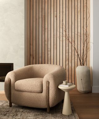 A seating corner with wood-paneled walls and a boucle armchair