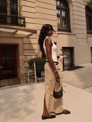 a photo of a woman's work outfit with black ballet flats styled with a tan pencil skirt and white turtleneck