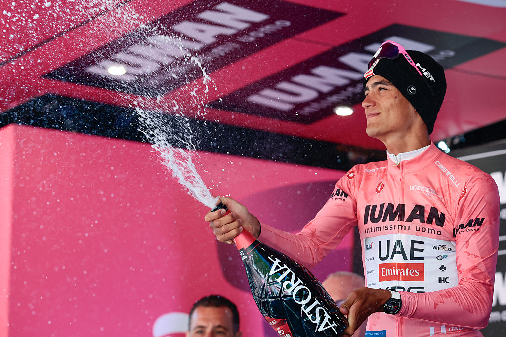 UAE Team Emirates XRG's Mexican rider Isaac Del Toro wearing the pink jersey of overall leader (Maglia Rosa) sprays champagne as he celebrates on the podium after placed second in the 19th stage of the 108th Giro d'Italia cycling race of 166kms from Biella to Champoluc on May 30, 2025. (Photo by Luca Bettini / AFP)