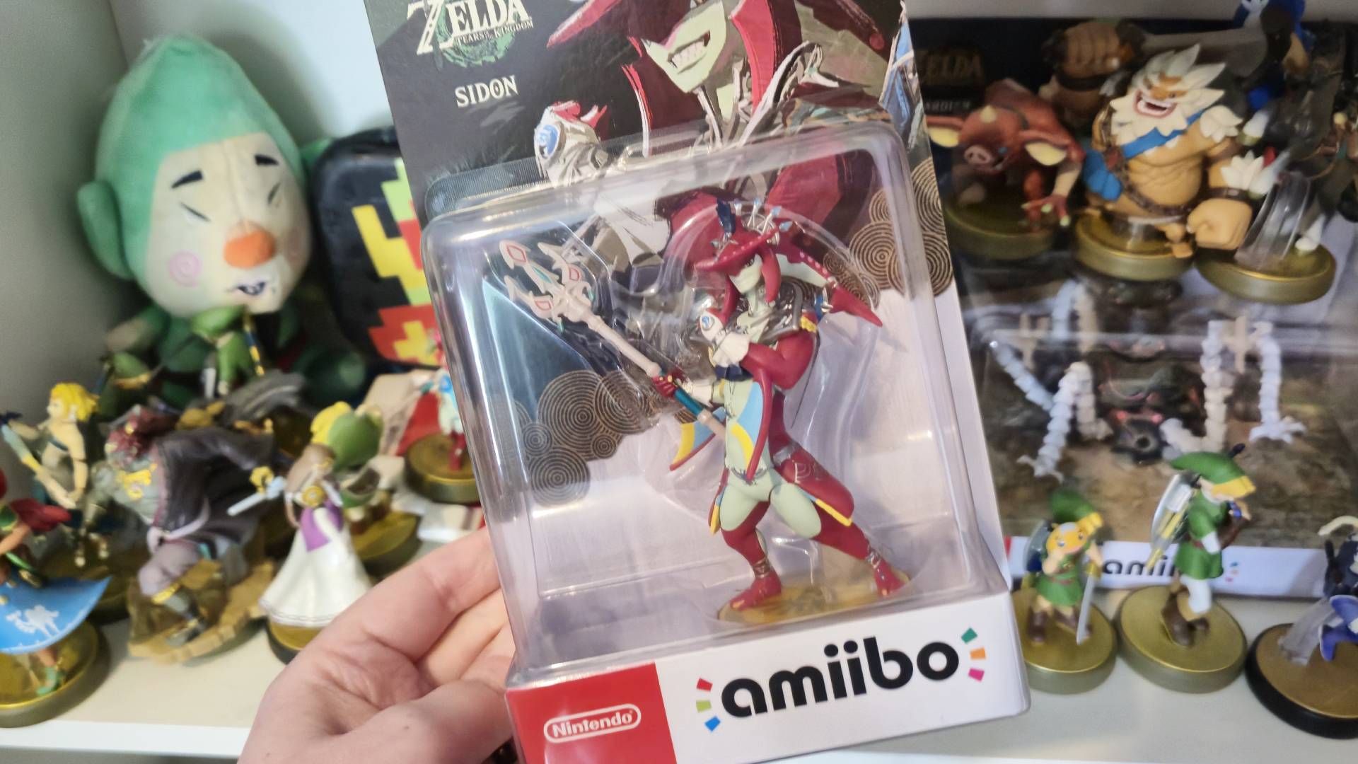 Photo of the Tears of the Kingdom Sidon amiibo taken by Rosalie Newcombe, sitting in front of a shelf of other Zelda amiibo figures.