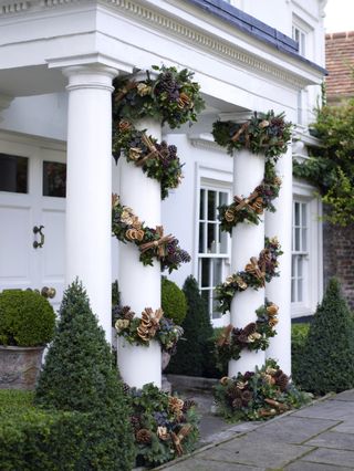 front porch pillars wrapped in pine cone garland