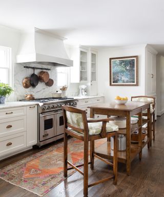 transitional white modern kitchen with stainless steel cooker and rustic wooden kitchen island and stools