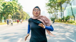 Woman running down a road during marathon training