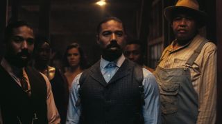 Twin Michael B Jordans stand guard at the door with Omar Benson Miller in Sinners.