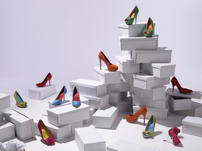 A stack of shoes boxes with shoes on top