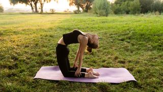 A woman holding a camel stretch