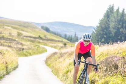 Image shows rider cycling in the sun.