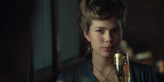 Josephine Thiesen as Princess Marie Charlotte of Belgium with her hair up and holding a champagne flute in 'The Empress.'