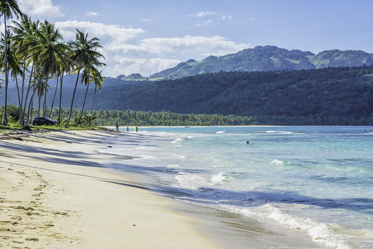 A view of the Playa Rincon beach in the Dominican Republic, with mountains in the background.