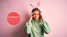 A woman wearing easter bunny ears rubs her head 