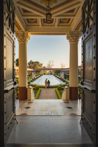 Getty Museum visitors stand at the fountain of the Outer Peristyle at the Getty Villa