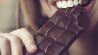 Woman biting dark chocolate