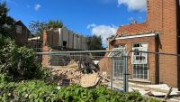 A three-storey home with its walls collapsed and a neighbouring home with the top two floors destroyed