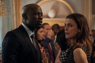 David Gyasi as Austin Dennison and Keri Russell as Kate Wyler in the diplomat season 2 speaking at a political function