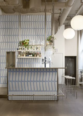A bar with a white tiled wall with chunky, oversized blue grouting