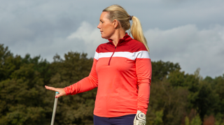 A golfer poses in the Puma Women’s Golf Lightweight 1/4 Zip Long Sleeve Top