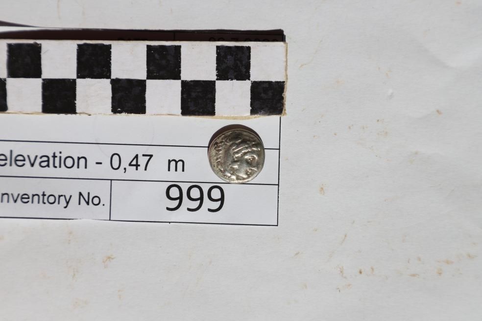 a close-up of a silver coin with a face