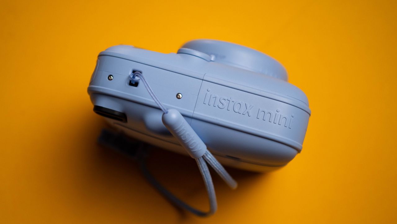 Fujifilm Instax Mini 13 instant camera against a yellow colored sheet