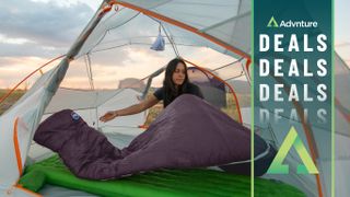 Woman unpacking sleeping bag in tent