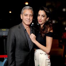 George and Amal Clooney pose in evening attire.