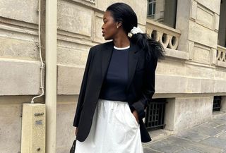 @nlmarilyn wearing a navy sweater with a blazer and a white poplin skirt.