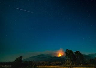 A bright Perseid meteor dashes across the sky above a wildfire near the village of Velmej in Macedonia in this photo by astrophotographer Stojan Stojanovski.