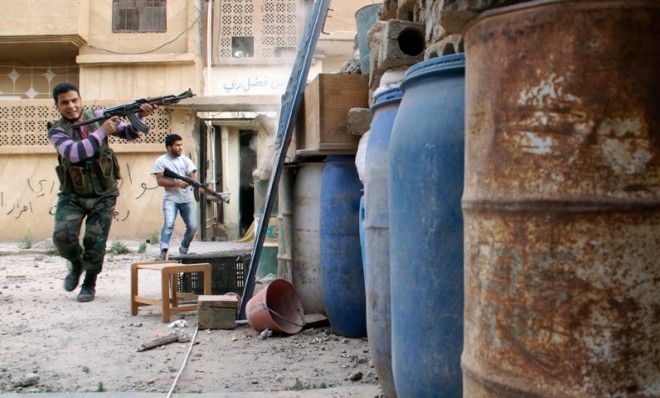 A Free Syrian Army fighter fires back at the Syrian Army in Deir Al-Zor.