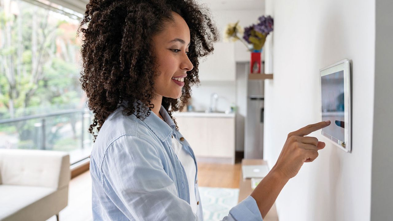 Woman prodding a tablet on a wall