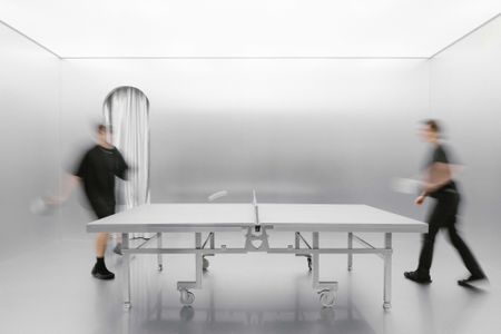 A silver room with a silver ping pong table