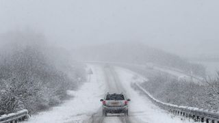 Car is driven along a slip road leading to the snow and sleet-covered A34 road a near Chievely
