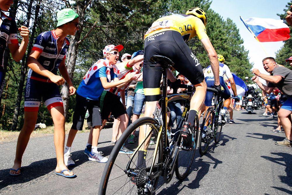 Chris Froome climbs through a gauntlet of spectators during stage 14.