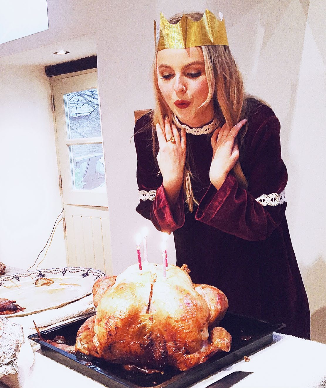 An adult Poppy blowing out her birthday candles on the Xmas turkey
