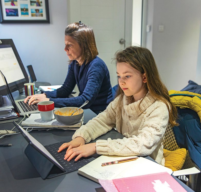 Young girl remote learning whilst her mother works from home