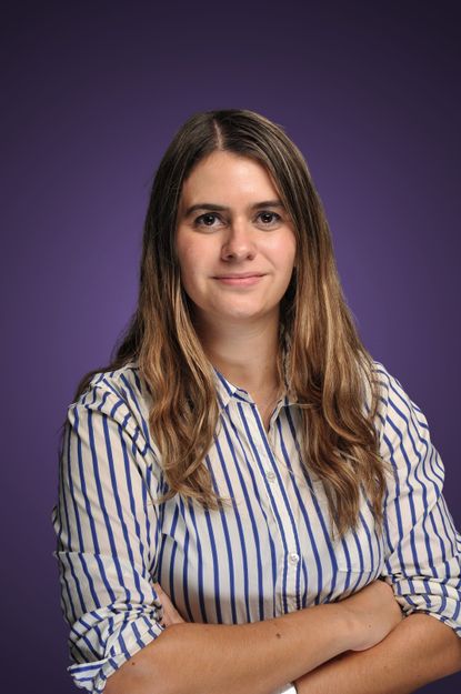 Alexandra Svokos in a striped blouse with a purple background.