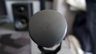 JBL Quantum Stream Studio microphone on a desk in front of a monitor