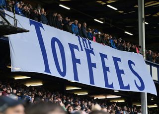 Everton fans at Goodison Park with a banner of the club's nickname, the Toffees