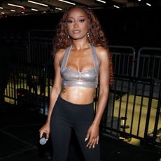 Keke Palmer wearing a braided hairstyle and a silver bralette top