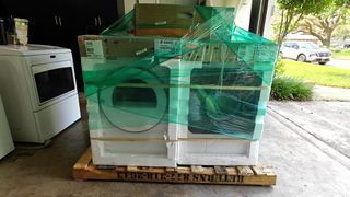 The ASKO Tumble Dryer T411VDW in packaging with the ASKO washer in reviewer's garage